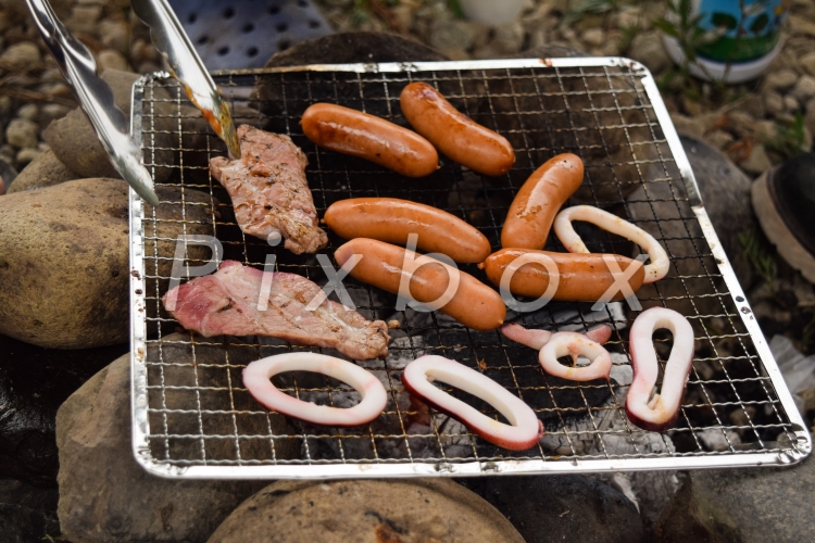 河原で簡易バーベキューの写真