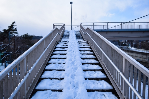 雪が積もった歩道橋階段の写真